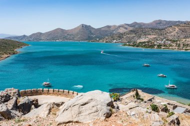 Spinalonga Adası en iyi. Tekneler ve Mirabello sahil aegian denize sıfır mavi olarak görüntülemek.