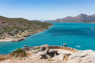 Spinalonga Adası en iyi. Aegian deniz tekne, Kalydon Adası ve Mirabello sahil ile mavi olarak görüntülemek.