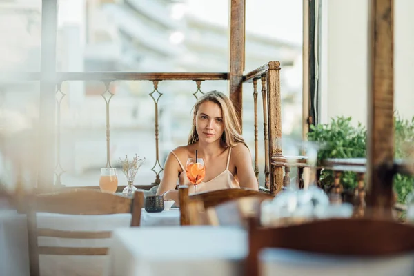 暑い夏の日に冷たいカクテルとカフェで美しい若い女性 ストックフォト