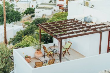 Kafe masaları ve sandalyeleri olan şirin bir balkon.