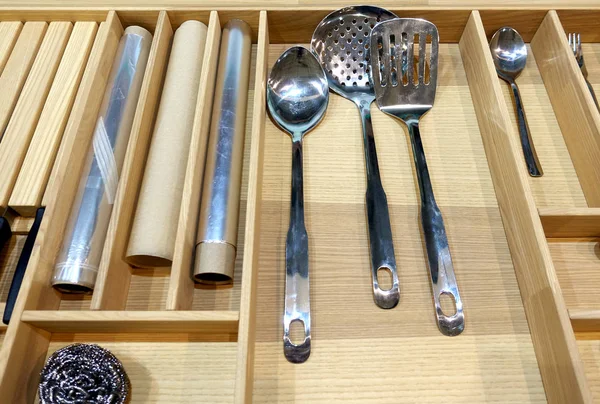 Spoons and other cutlery in a wooden cutlery box drawer