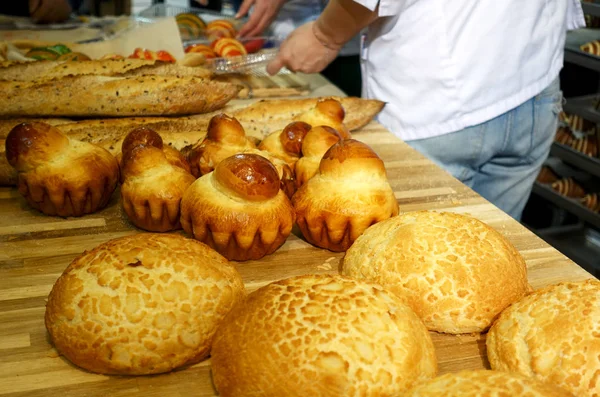 パンの種類は パン屋で木製のテーブル ロールします — ストック写真