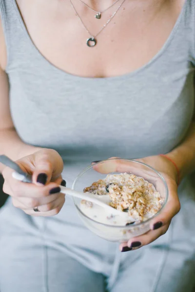 Vrouwelijke handen met een lepel van muesli — Stockfoto