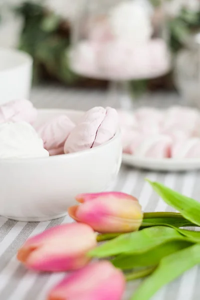 Чашка и белый и розовый зефир на украшенном столе — стоковое фото
