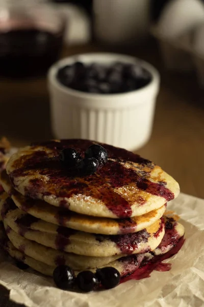 A stack of gluten-free pancakes with black currant on a dark background and topping — Stock Photo, Image