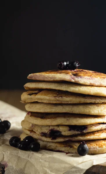 Oatmeal pancakes with black currant close-up on a black background — Stock Photo, Image
