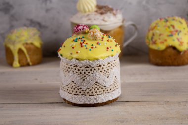 Paskalya çörekleri, şeker süslemeleri, ahşap bir masaya serpiştirme ve beton bir arka plan.