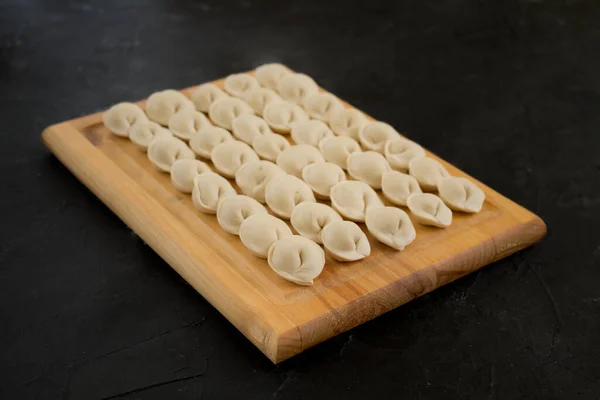 stock image Uncooked Russian homemade dumplings or ravioli on the Board. The view from the top