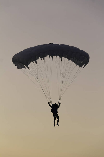 Silhouette of a parachutist on a sunset sky