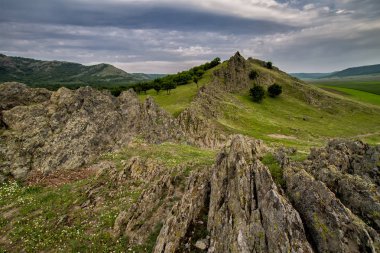Güzel bahar peyzaj kayalar, ağaçlar ve bulutlar Macin Dağları, Dobrogea, Romanya