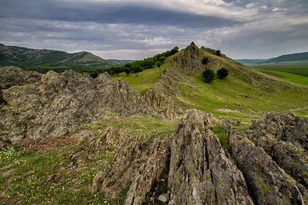 Güzel bahar peyzaj kayalar, ağaçlar ve bulutlar Macin Dağları, Dobrogea, Romanya