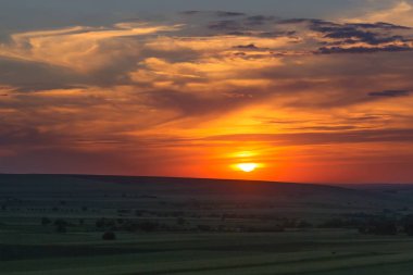 Bulutlu renkli günbatımı ağaçlar, Dobrogea, Romanya ve tepeler üzerine