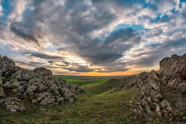 Yeşil bitki örtüsü, kayalar ve mavi bir günbatımı gökyüzü bulutlu, Dobrogea, Romanya güzel manzara