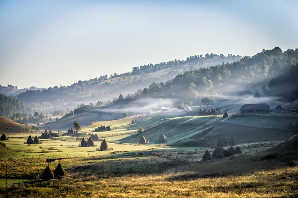 Schöne Ländliche Berglandschaft Morgenlicht Mit Nebel Alten Häusern Und Heuhaufen — Stockfoto