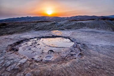 Beautiful lunar landscape with a sunset over the muddy volcanoes, Paclele, Berca, Buzau County, Romania