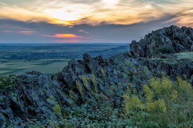 Günbatımı gökyüzü ve ilkbaharda kayalıklarda beyaz çiçeklerle güzel manzara, Dobrogea, Romanya