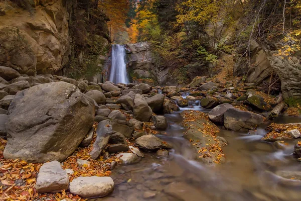 Long exposure view of the beautiful Pruncea Casoca Waterfall with fallen leaves in an autumn landscape,Siriu, Buzau, Romania