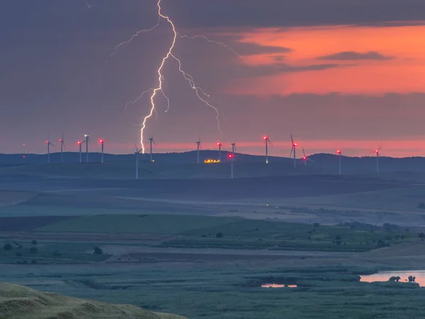 在落日的天空中 用风力涡轮机和湖泊在山上打雷 Enisala Dobrogea 罗马尼亚 — 图库照片