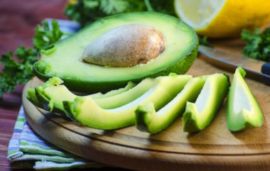 bir kesme tahtası üzerinde avokado dilimlenmiş