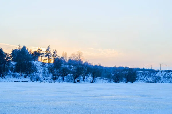 Foresta invernale e il fiume al tramonto — Foto Stock