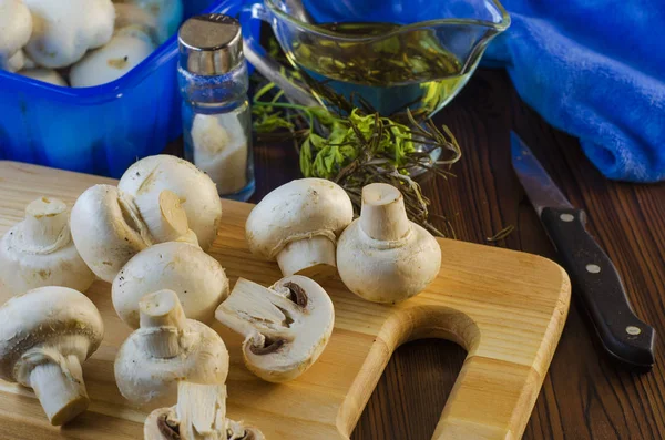 Mushrooms champignons on the kitchen board — Stock Photo, Image