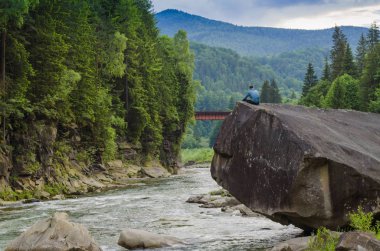 Kayanın üzerinde güzel bir yerde adam derin derin düşünür