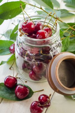 Bir cam vazo ve bir kavanoz olgun kestane kiraz