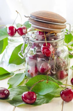 Bir cam vazo ve bir kavanoz olgun kestane kiraz