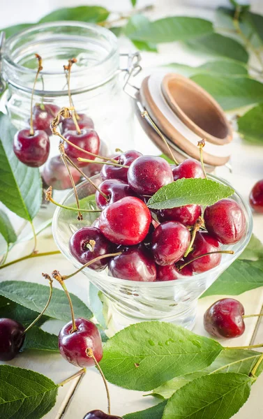 Bir cam vazo ve bir kavanoz olgun kestane kiraz