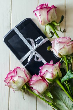 tablet hediye olarak bir yay ve çiçekler ile