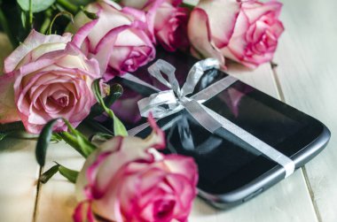 tablet hediye olarak bir yay ve çiçekler ile