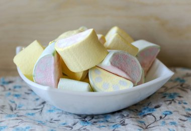 Marshmallow ile ışık ahşap arka plan üzerinde bir fincan çok renkli bir desen