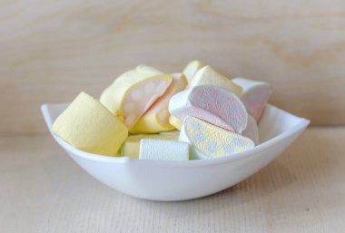 Marshmallow ile ışık ahşap arka plan üzerinde bir fincan çok renkli bir desen