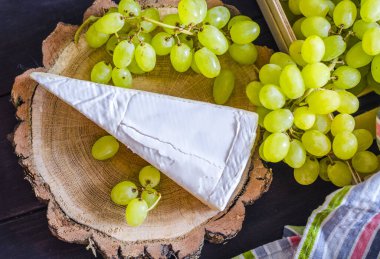 Brie peyniri ve tahtadan yapılmış taze üzümler