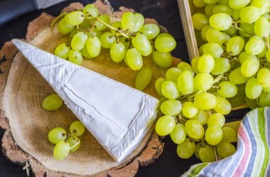 Brie peyniri ve tahtadan yapılmış taze üzümler