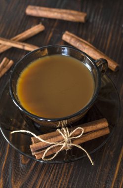 Bardakta kahve ve masada tarçın.