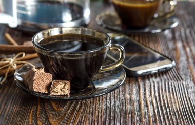 Masanın üzerinde sade kahve ve çikolata var.