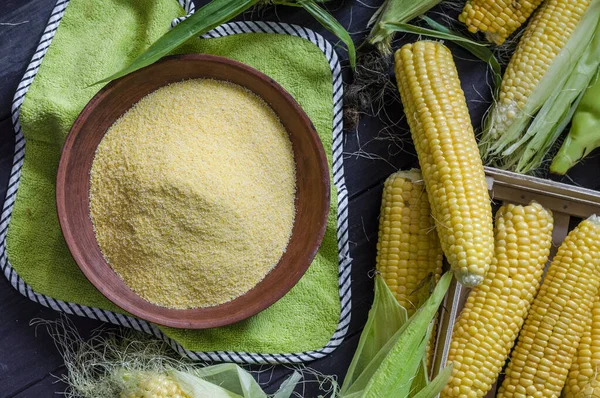 Bir kasede küçük mısır ezmesi ve masada sallanan mısır.