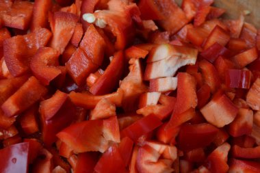 Biber. Capsicum annuum. Kırmızı biber dilimleri. Yakın çekim. Bölme. Bir kesme tahtası üzerinde. Mutfak. Yemek yemek. Yatay