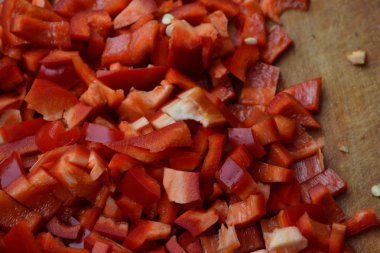 Biber. Capsicum annuum. Kırmızı biber dilimleri. Yakın çekim. Bölme. Bir kesme tahtası üzerinde. Mutfak. Yatay