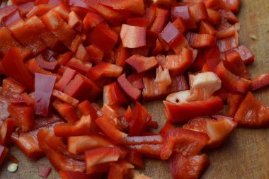 Biber. Capsicum annuum. Kırmızı biber dilimleri. Yakın çekim. Bölme. Bir kesme tahtası üzerinde. Mutfak. Yatay fotoğraf