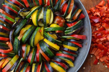 Ratatouille. Sebze tabağı. Köylü gıda. Sebze, dilimler halinde kesin. Kabak, biber, domates, patlıcan. Mutfak. Lezzetli. Yararlı olur. Yakın çekim. Yatay fotoğraf