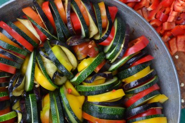 Ratatouille. Sebze tabağı. Köylü gıda. Sebze, dilimler halinde kesin. Kabak, biber, domates, patlıcan. Mutfak. Yemek tarifleri. Lezzetli. Yararlı olur. Yatay