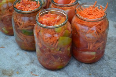 Ev yapımı. Kış için kuru sıkı. Kavanozda rendelenmiş havuç, kırmızı ve sarı domates.