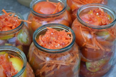 Ev yapımı. Korumak. Kış için kuru sıkı. Salamuraya yatırılmış. Kavanozda rendelenmiş havuç, kırmızı ve sarı domates.