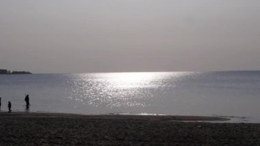 İnsanlar deniz kıyısında yürür