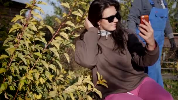 Девушка делает селфи в саду — стоковое видео