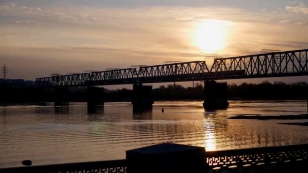 Saliendo del tren a través del río al atardecer — Vídeo de stock