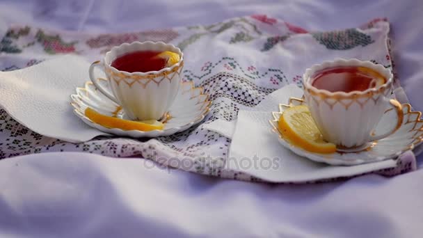 Лимонный чай в чашках на закате — стоковое видео