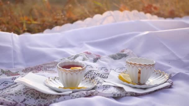 Two cups of tea with lemon at sunset . — Stock Video